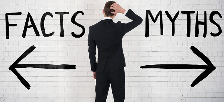 Cybersecurity Myths Man in Suit Looking at a White Wall With Two Direction Arrows Pointed To Fact or Myths